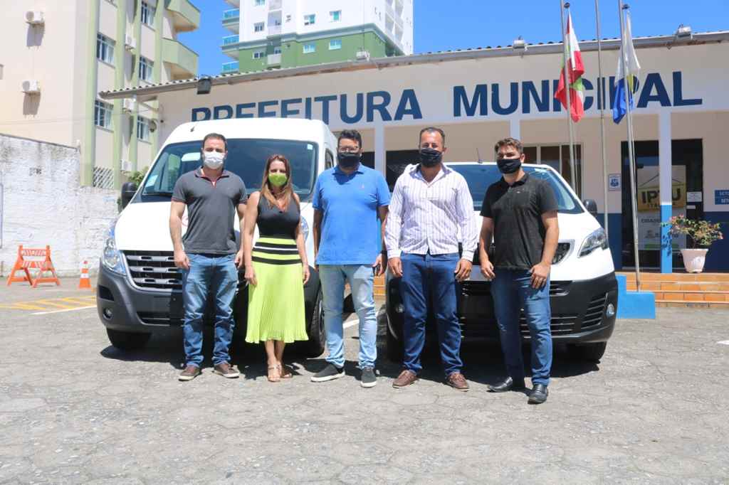 Prefeita Nilza Simas entre dois novos veículos para a saúde